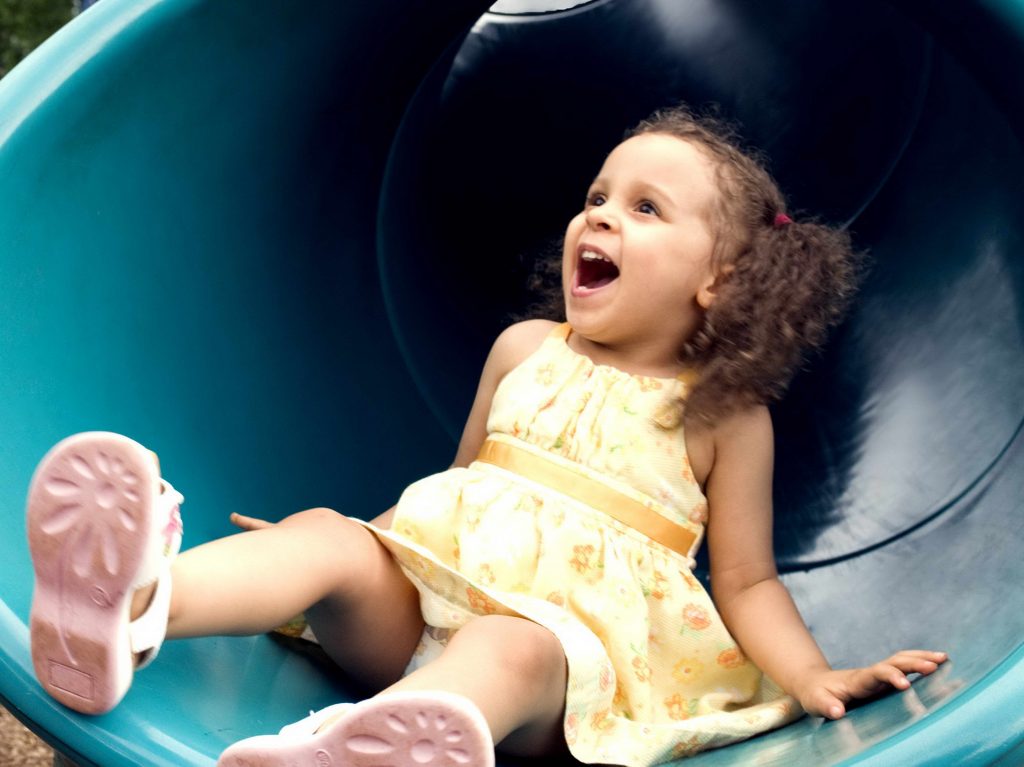 young girl on park slide